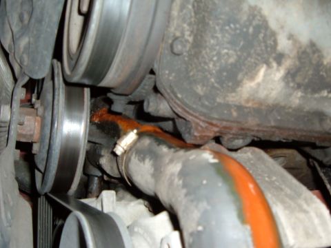 1988 Ford Bronco - Visible engine coolant leak dripping onto the belt and pulleys, indicating a potential repair need.