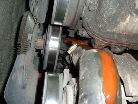 1988 Ford Bronco - Close-up view of a leaking engine cooling hose and associated pulleys.