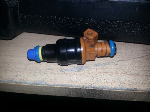 1994 Ford Bronco - A single fuel injector is shown against a textured background.