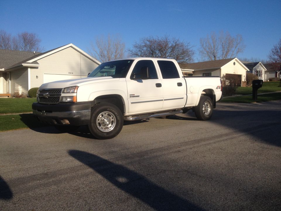 White 2006 Chevrolet Silverado 2500 pickup truck parked on a residential street, viewed from the front 3/4 angle