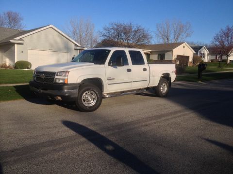 2006 Chevrolet Silverado 2500 - White 2006 Chevrolet Silverado 2500 crew cab pickup truck parked in front of a suburban house.