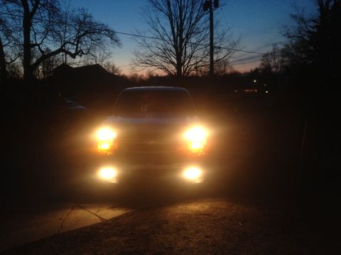 2006 Chevrolet Silverado 2500 - The front of a truck is visible at dusk with its headlights illuminated.
