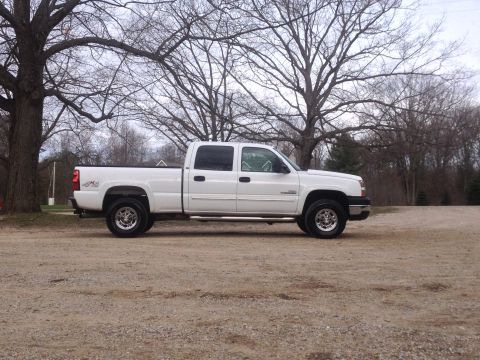 2006 Chevrolet Silverado 2500 - A white 2006 Chevrolet Silverado 2500 pickup truck is shown from the side on a gravel lot.