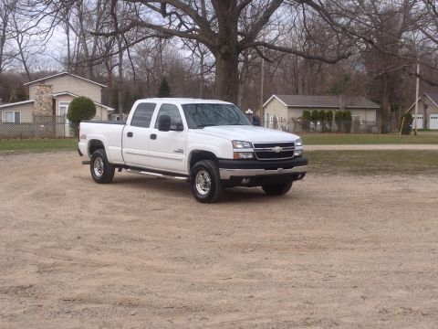 2006 Chevrolet Silverado 2500 - This white 2006 Chevrolet Silverado 2500 pickup truck is shown from a 3/4 front angle in a rural setting.