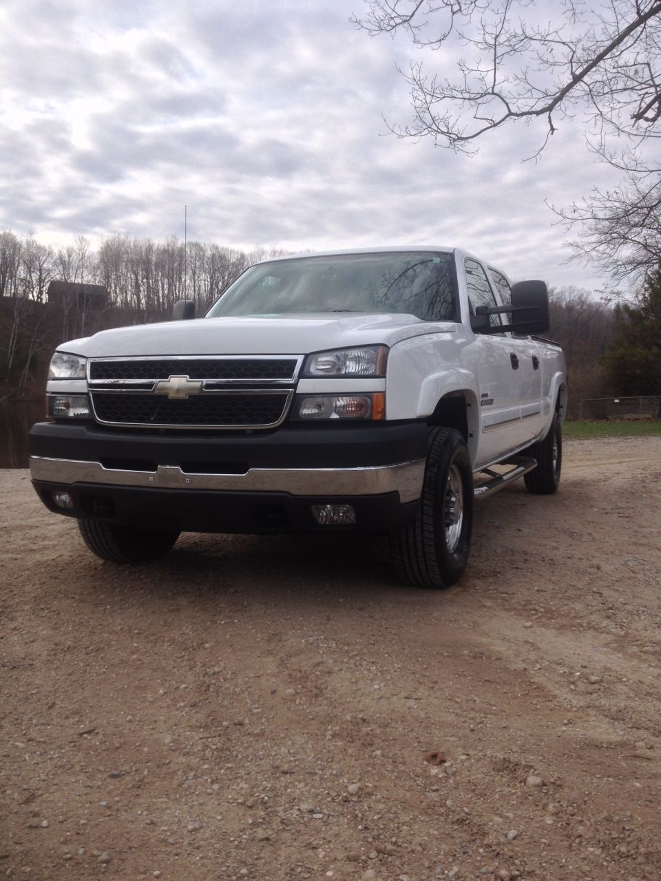 White 2006 Chevrolet Silverado 2500 pickup truck parked on a dirt road