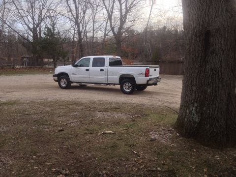 2006 Chevrolet Silverado 2500 - This white 2006 Chevrolet Silverado 2500 crew cab pickup truck is seen from a 3/4 front angle in an outdoor setting.