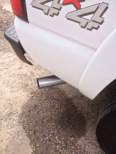 2006 Chevrolet Silverado 2500 - Close-up of a white pickup truck's rear side, showing the exhaust and a 4x4 decal.