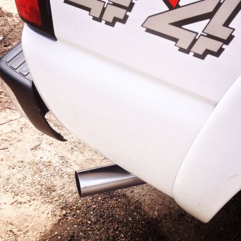 2006 Chevrolet Silverado 2500 - Close-up of a white pickup truck's rear, showing a 4x4 decal and exhaust pipe.