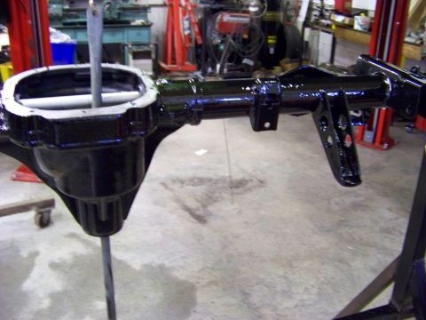 1999 Mercury Grand Marquis - A black painted rear axle assembly is shown in a workshop setting, suspended on a stand.