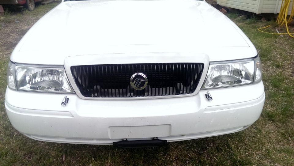White Mercury Grand Marquis front grille and headlights, with a black grille and chrome Mercury emblem
