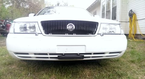 2000 Mercury Grand Marquis - Front view of a white 2000 Mercury Grand Marquis, its distinctive vertical grille and headlights.