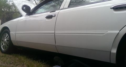 2000 Mercury Grand Marquis - White 2000 Mercury Grand Marquis with hood open, seen from the side.