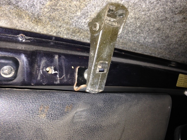 Interior latch mechanism on black trim with gray carpeted headliner
