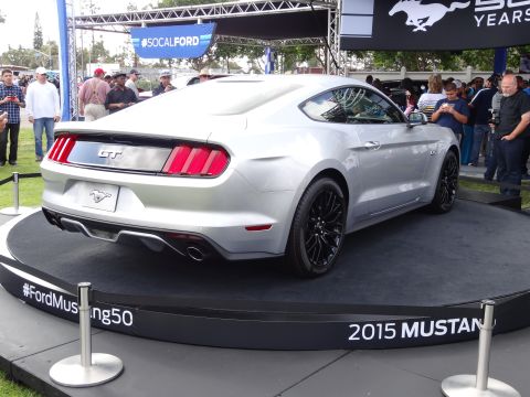 1994 Ford Bronco - A silver 2015 Ford Mustang GT is displayed on a platform with "#FordMustang50" and "2015 MUSTANG" visible.