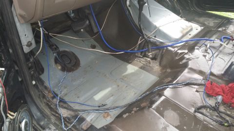 1994 Ford Bronco - The floor of this vehicle is stripped down, showing exposed wires and the metal floor pan.