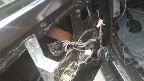 1994 Ford Bronco - The interior of a car door reveals exposed wiring and components, suggesting repair or modification.