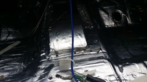 1994 Ford Bronco - Vehicle interior undergoing soundproofing installation, with exposed wiring and insulation material.