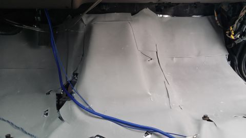 1994 Ford Bronco - The interior of a vehicle shows soundproofing material and exposed wiring.