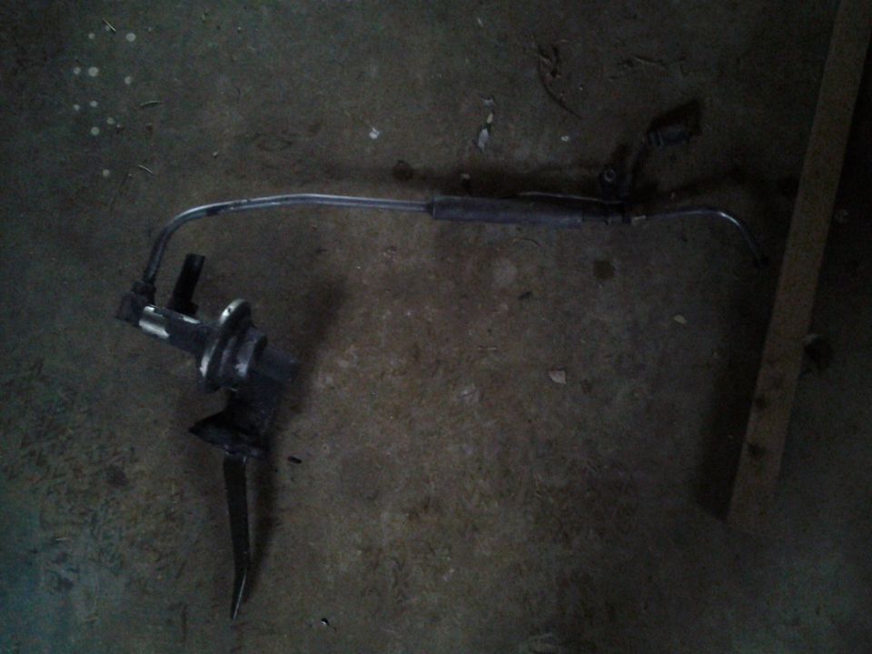 Steering component with metal rod and black housing on a concrete floor
