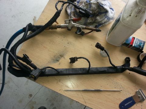 1994 Ford Bronco - Engine wiring harness and tools on a workbench, likely for repair or maintenance.