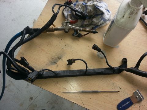 1994 Ford Bronco - A vehicle's engine wiring harness is shown on a workbench, possibly during maintenance or repair.