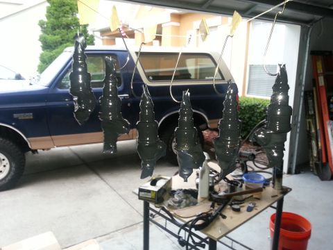 1994 Ford Bronco - Six spark plugs hang drying in front of a Ford Bronco, possibly from the early 1990s.