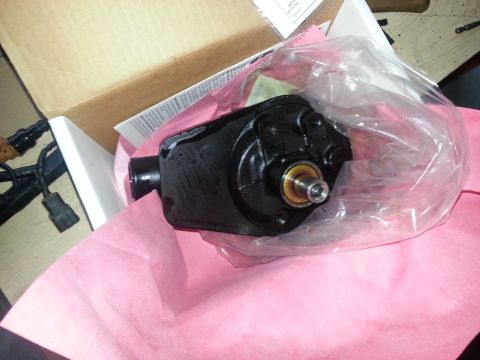 1994 Ford Bronco - A black power steering pump is shown in its packaging, alongside an open cardboard box.