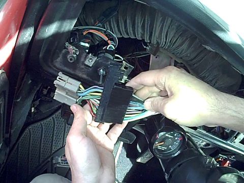 1978 Ford Bronco - Close-up of a vehicle's interior showing a person working on the wiring harness and ignition switch.