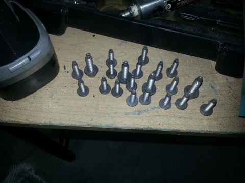 1994 Ford Bronco - Engine bolts are laid out on a workbench, ready for installation or removal.