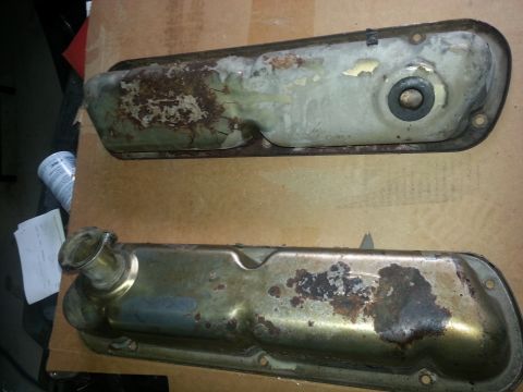 1994 Ford Bronco - Two used valve covers, showing signs of rust and wear, are laid out on a cardboard surface.