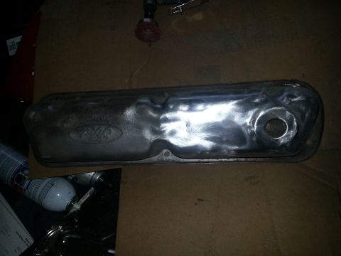 1994 Ford Bronco - A metal Ford valve cover is shown, likely undergoing restoration or modification.