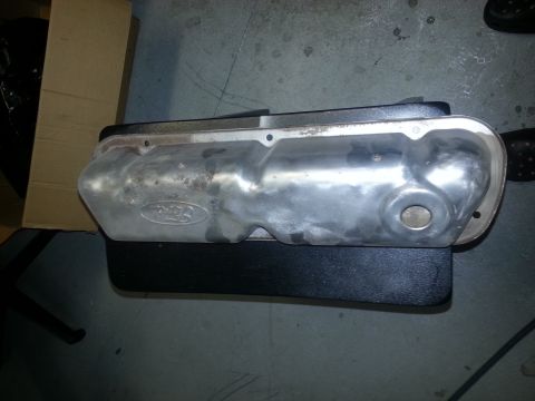 1994 Ford Bronco - Metal valve cover with Ford logo. The part is on a dark surface with a cardboard box in the background.