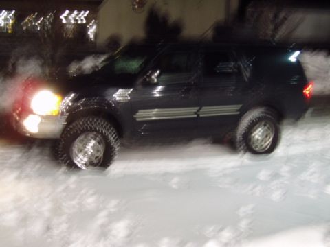 1998 Ford Expedition - Dark 1998 Ford Expedition navigates a snowy road at night with its headlights illuminated.