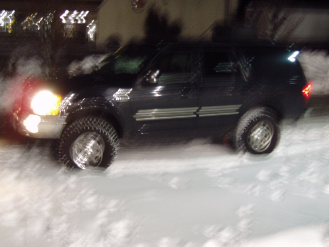 1998 Ford Expedition driving in snow at night, headlights on