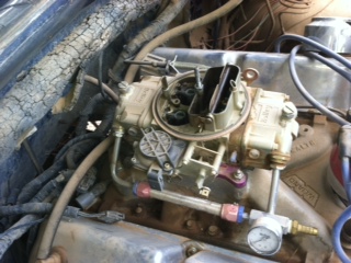 1995 Ford Bronco - Close-up view of an engine's carburetor, showing fuel lines and electrical connections.