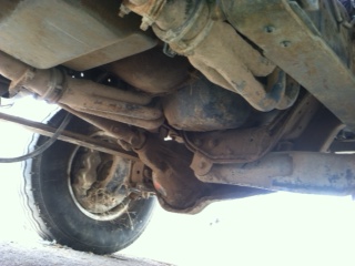 1995 Ford Bronco - Close-up of the undercarriage, showing suspension and exhaust parts. SuperMotors.net logo is present.