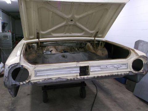 1964 Ford Galaxie - The rear of a 1964 Ford Galaxie is shown with its trunk open, revealing the interior and some rust damage.