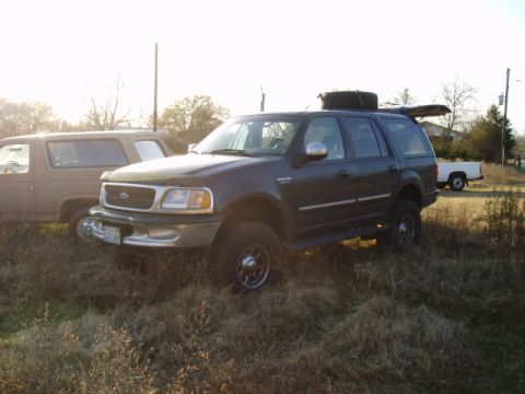 1998 Ford Expedition - Dark gray Ford Expedition parked in a grassy field with another SUV nearby.