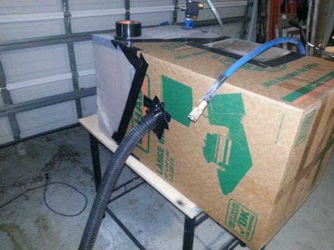 1994 Ford Bronco - A makeshift enclosure is constructed from a cardboard box and plastic sheeting, with hoses connected for ventilation or air supply.