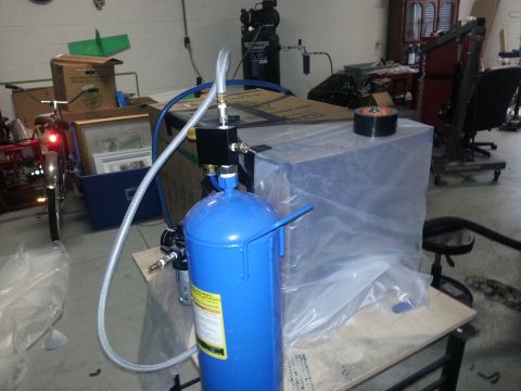 1994 Ford Bronco - A blue air compressor tank is connected to a larger covered object, with a bicycle visible in the background.