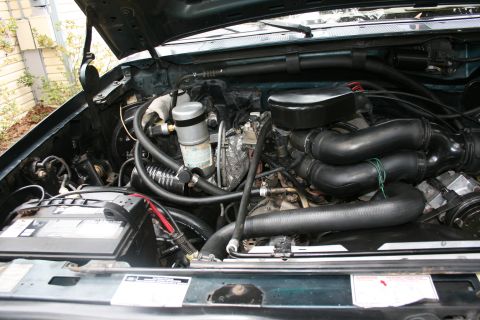 1994 Ford Bronco - Close-up of an engine bay, showing various mechanical parts and the battery.