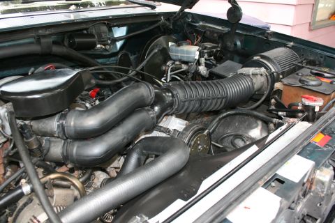 1994 Ford Bronco - Close-up view of the engine compartment, showing various hoses and the air intake system.