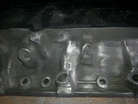 1994 Ford Bronco - A close-up view of a metal engine block component, showing cast textures and bolt mounting points.