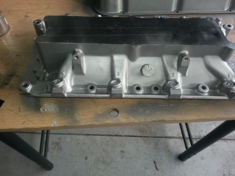 1994 Ford Bronco - Aluminum intake manifold on a workbench, likely for an engine rebuild or upgrade.