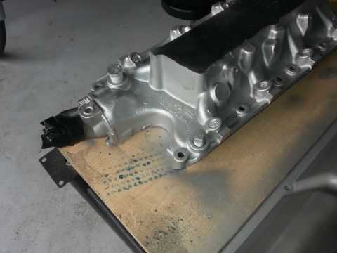 1994 Ford Bronco - A silver Ford intake manifold is shown, with black tape covering a portion of it.