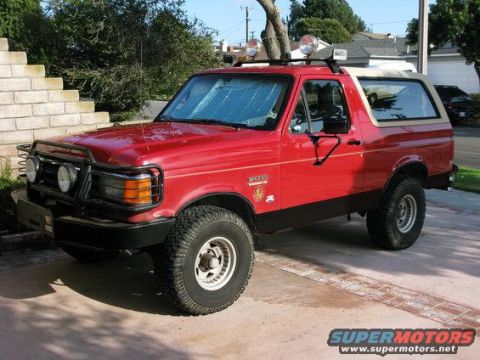 1994 Ford Bronco - This red Ford Bronco features off-road modifications and a two-tone paint scheme.