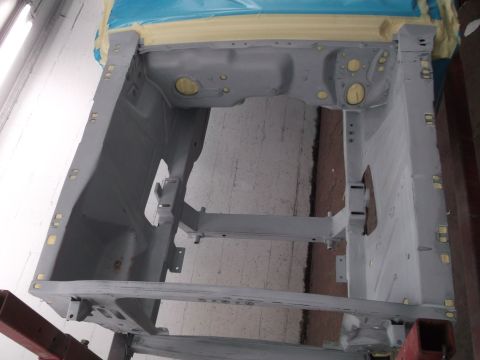 1967 Ford Mustang - The bare frame of a car, likely a 1967 Ford Mustang, is shown during a restoration process.