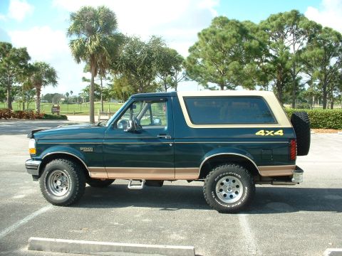 1994 Ford Bronco - This Ford Bronco SUV, with its distinctive two-tone paint and spare tire, is viewed from the side.