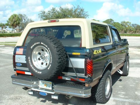 1994 Ford Bronco - Rear view of a Ford Bronco with a spare tire and "4x4" decal, parked outdoors.