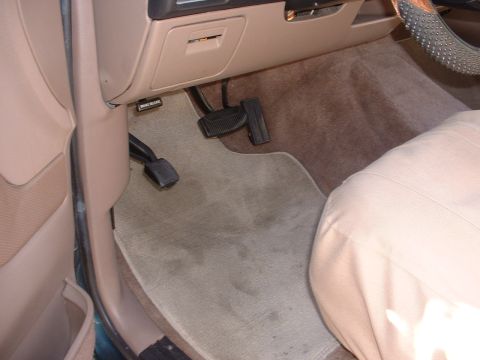 1994 Ford Bronco - The driver's side footwell shows the brake and gas pedals, along with the floor mat and part of the seat.